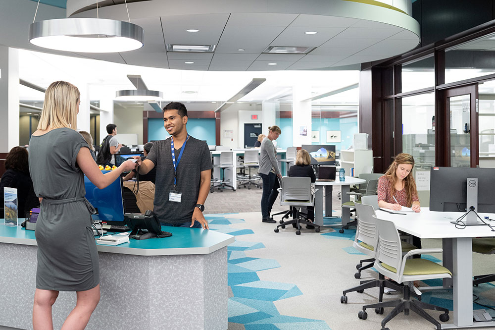 Two students at Library service desk