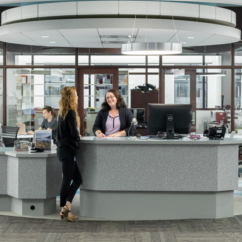 Student speaking with library staff at the Library Service Desk